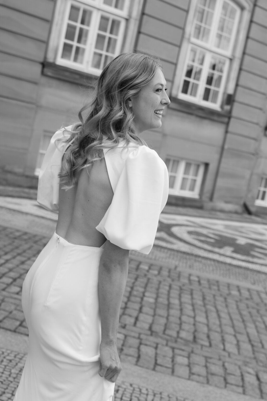 Braut in Rückansicht mit locker fallender Frisur – lässige Eleganz für moderne Hochzeiten.