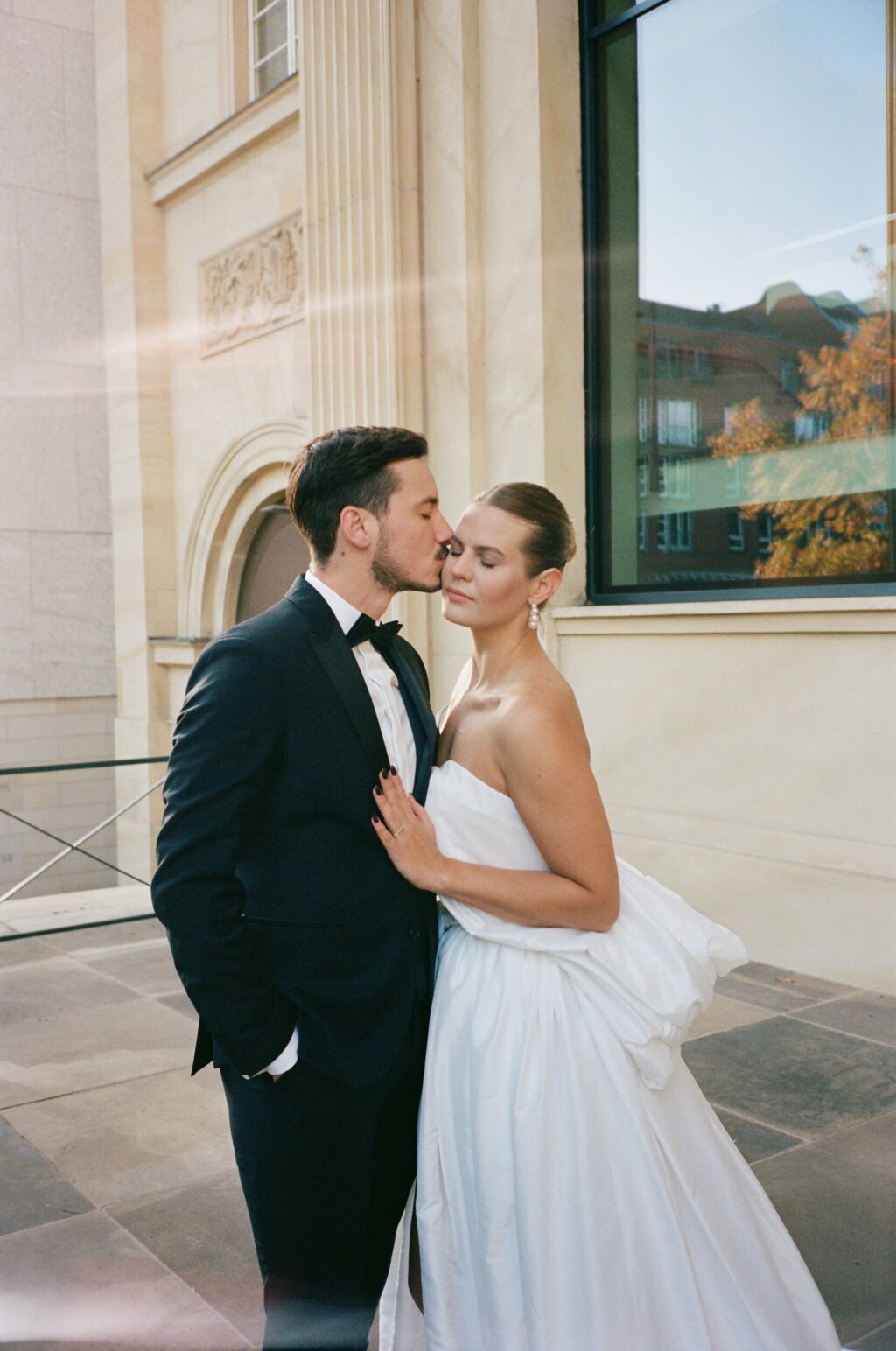 Brautpaar in eleganter Pose vor historischer Hochzeitslocation – stilvolle Urban Wedding.
