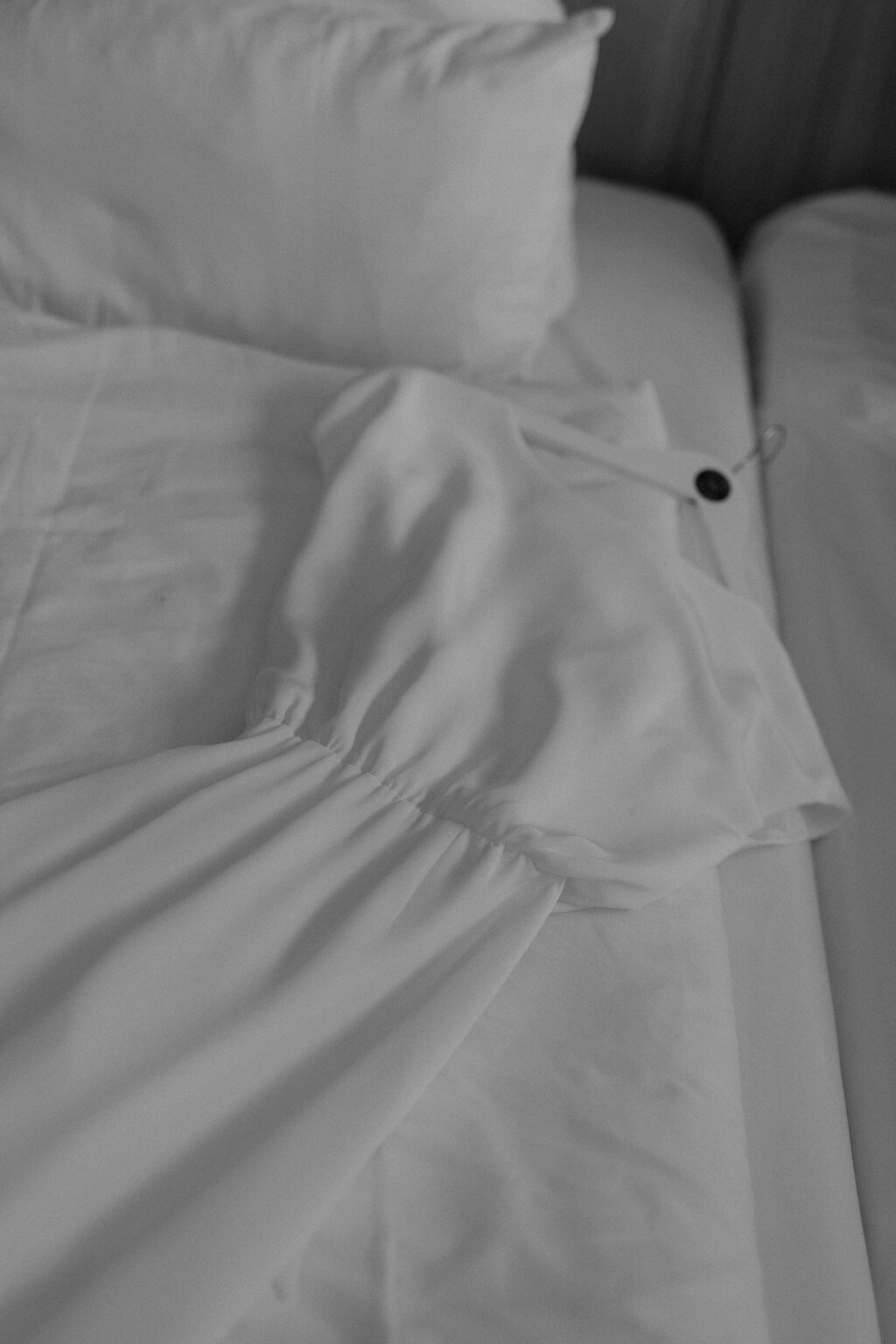 Hochzeitskleid liegt auf einem Bett, bereit zum Anziehen.
