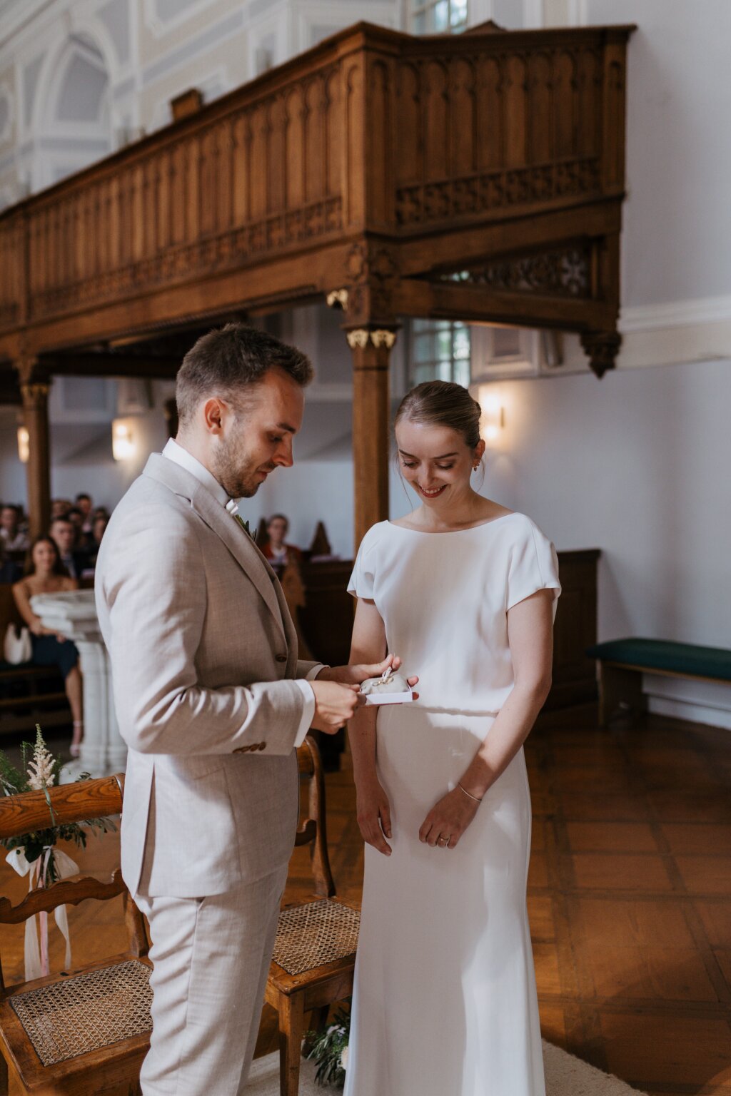 Bräutigam überreicht der Braut in der Kirche die Ringe – emotionaler Moment.