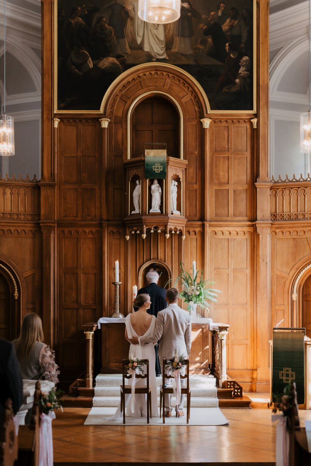 Brautpaar steht gemeinsam vor dem Altar der historischen Kirche.