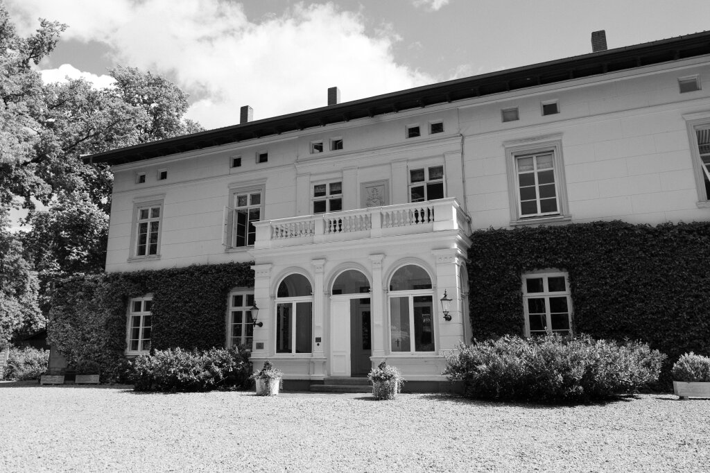 Historisches Herrenhaus mit langer Fensterfront und Efeu – eine märchenhafte Kulisse für den Hochzeitstag.