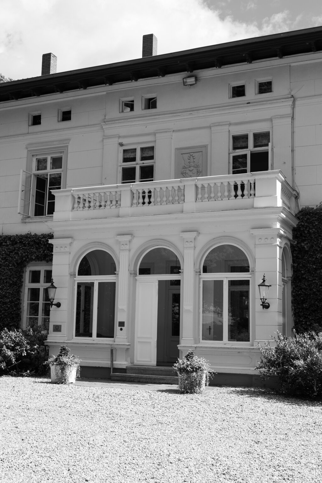 Frontalansicht eines stilvollen Herrenhauses mit klassischer Architektur und Efeubewuchs – ideal für eine Hochzeit im Vintage-Stil.