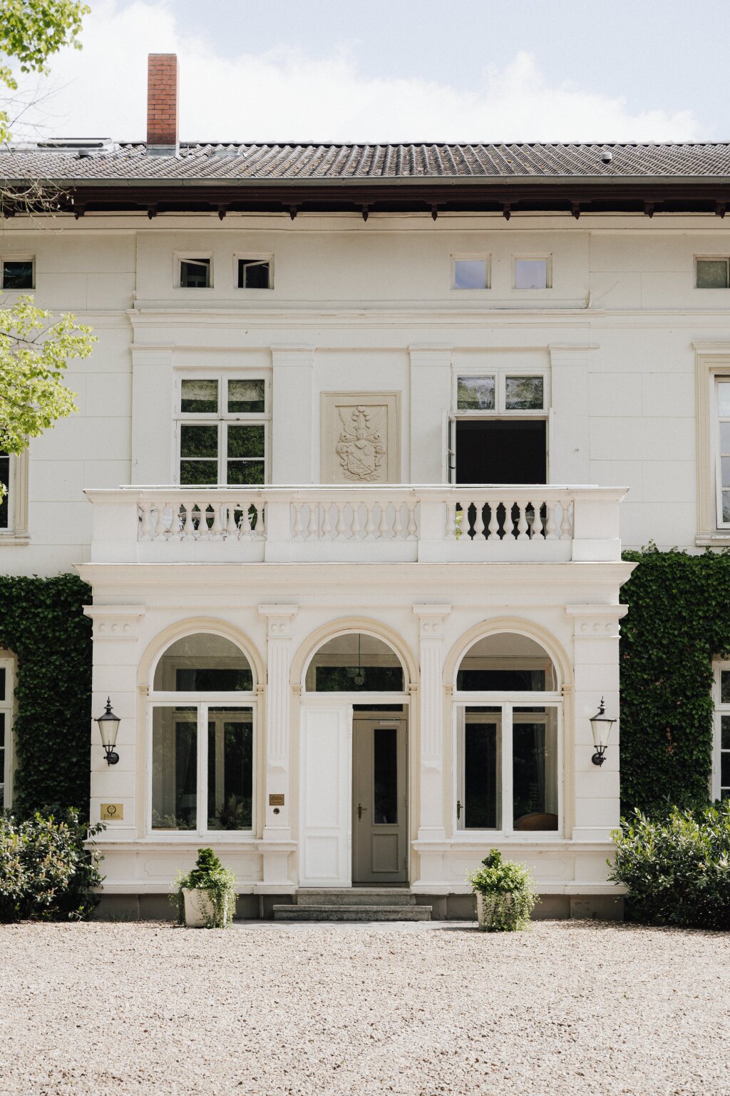 Fenster eines charmanten Herrenhauses, umgeben von wildem Wein – romantisches Flair für Hochzeiten.