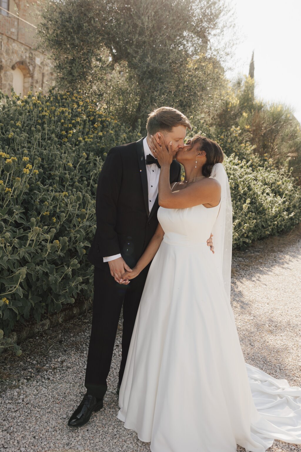 Bride and groom kissing in die shadow of a tree. Thy got eloped at Tuscany.