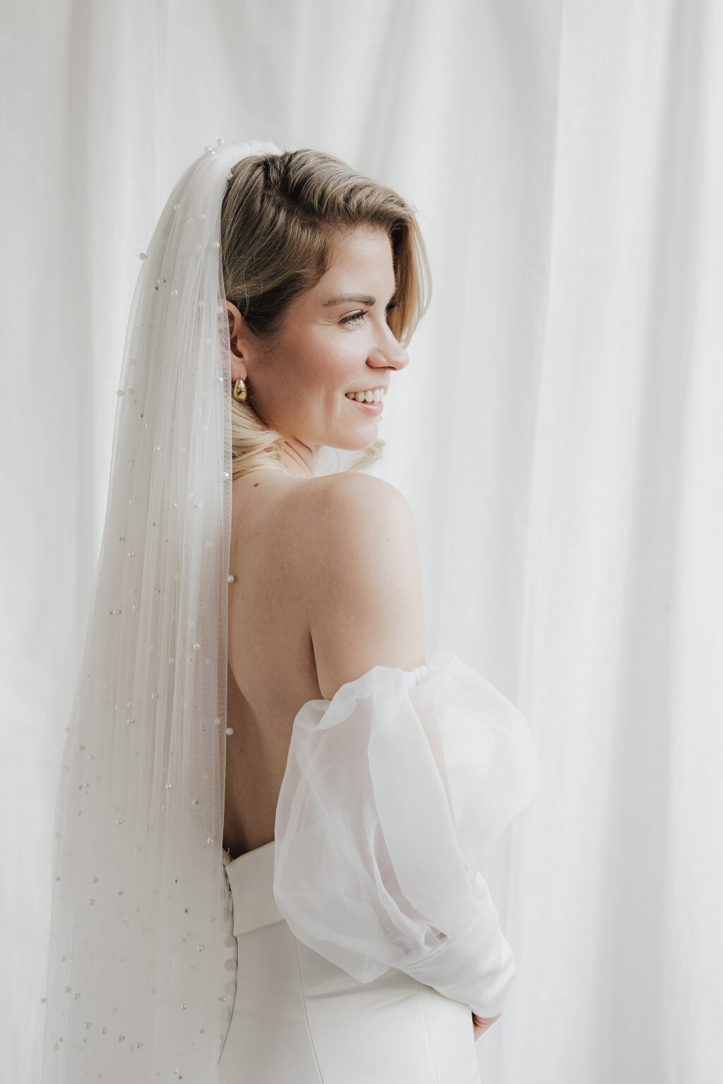 the bride with her veil smiling right before the ceremony.