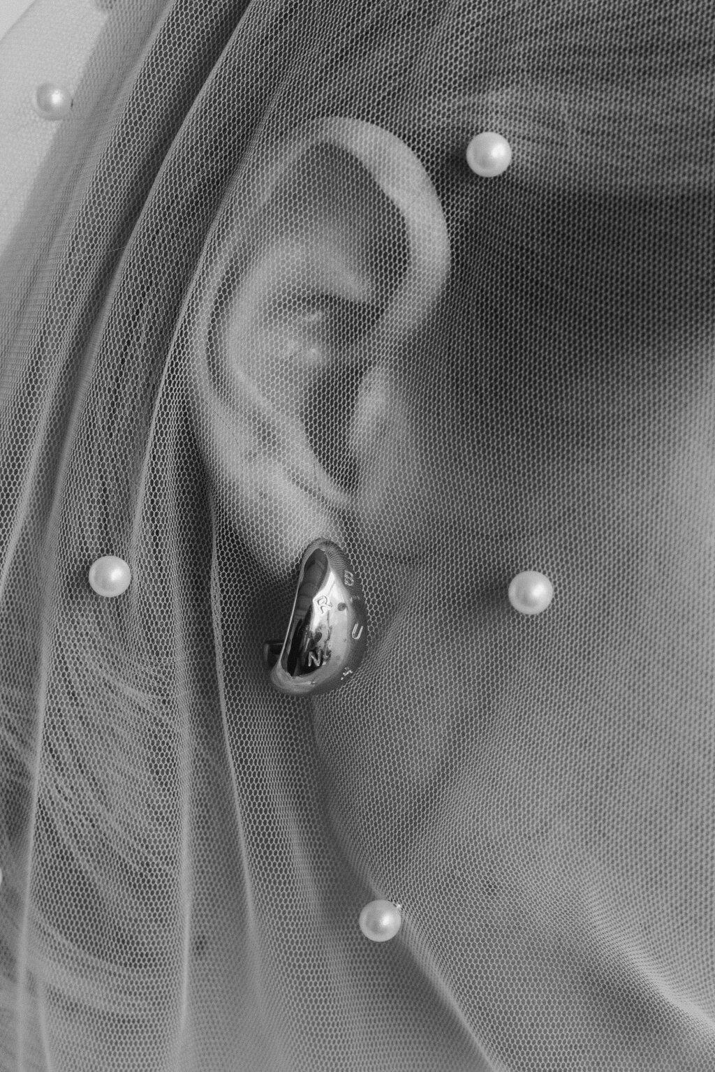 some details of the bride. Earring on top of the veil.