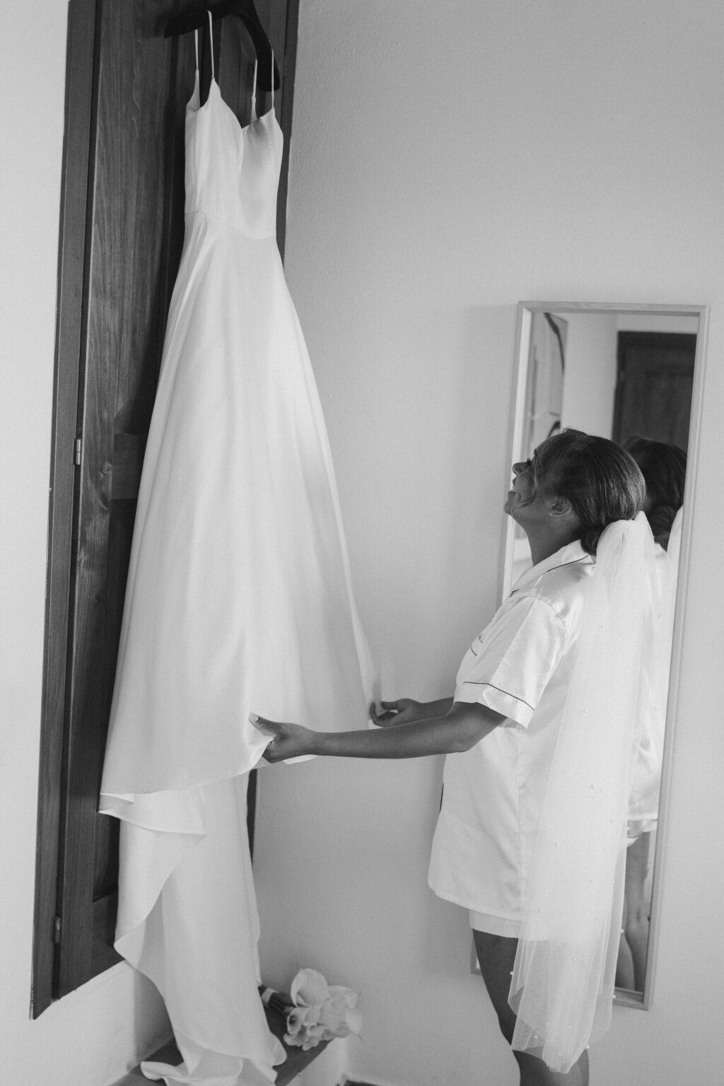 The bride admires her dress before putting it on.